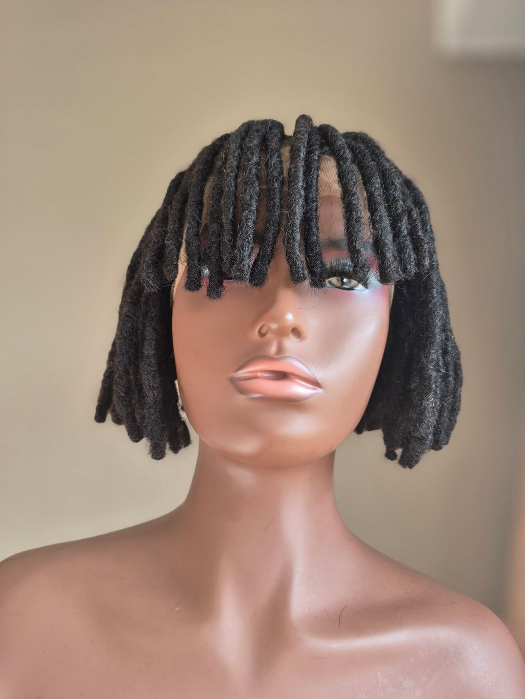 Short black loc bob with fringe, front view on mannequin